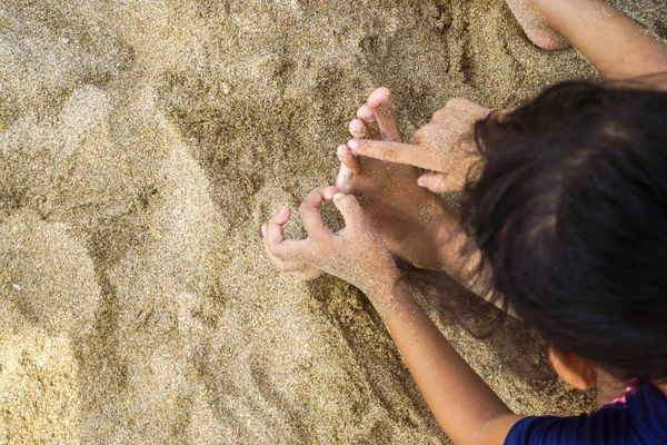 Head and feet of a small child on the beach
