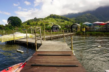 Göl kıyısında küçük bir iskelesi olan doğal manzara.
