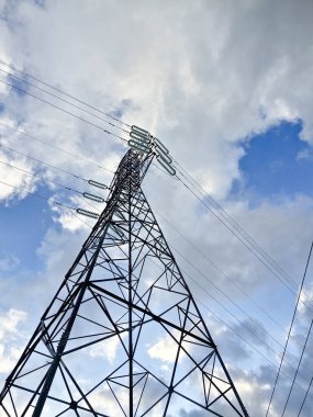Bulutlu mavi gökyüzü arkaplanlı elektrik kulesi