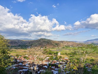 Yerel evlerin ve binaların cazibesi öğleden sonra güneşinin altında, bulutların içinden ışık huzmeleri akıyor.