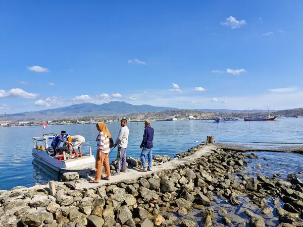 Balıkçı teknelerinden taze balık boşaltan işçiler balık almak için beklerken, balık limanında yoğun bir aktivite var.