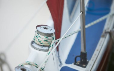 Limandaki yelkenli teknede vinç ve denizcilik halatları.