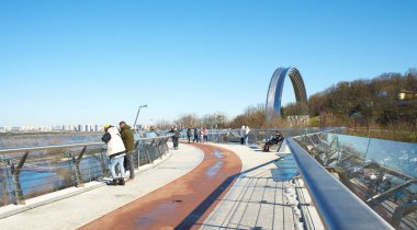 Kyiv, Ucraine-03.30.2023: Saint Volodymyr üzerinden Ukrayna 'nın başkenti Kyiv' e inen yaya ve bisiklet köprüsü. Glass Bridge, modern yaya köprüsü Kyiv 'in tarihi merkezini Arka Druzhby Narodiv' e bağlıyor.