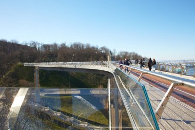 Kyiv, Ucraine-03.30.2023: Saint Volodymyr üzerinden Ukrayna 'nın başkenti Kyiv' e inen yaya ve bisiklet köprüsü. Glass Bridge, modern yaya köprüsü Kyiv 'in tarihi merkezini Arka Druzhby Narodiv' e bağlıyor.