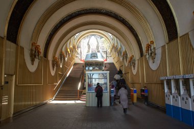 Yamaç boyunca uzanan raylarda mavi ve beyaz bir füniküler kablo yükselir. Füniküler tramvay, yan görüş. Kyiv İstasyonu, Ukrayna