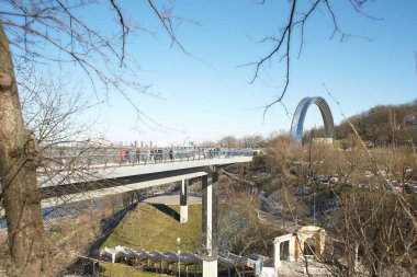 Kyiv, Ucraine-03.30.2023: Saint Volodymyr üzerinden Ukrayna 'nın başkenti Kyiv' e inen yaya ve bisiklet köprüsü. Glass Bridge, modern yaya köprüsü Kyiv 'in tarihi merkezini Arka Druzhby Narodiv' e bağlıyor.