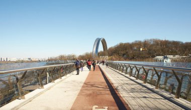 Kyiv, Ucraine-03.30.2023: Saint Volodymyr üzerinden Ukrayna 'nın başkenti Kyiv' e inen yaya ve bisiklet köprüsü. Glass Bridge, modern yaya köprüsü Kyiv 'in tarihi merkezini Arka Druzhby Narodiv' e bağlıyor.