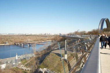 Kyiv, Ucraine-03.30.2023: Saint Volodymyr üzerinden Ukrayna 'nın başkenti Kyiv' e inen yaya ve bisiklet köprüsü. Glass Bridge, modern yaya köprüsü Kyiv 'in tarihi merkezini Arka Druzhby Narodiv' e bağlıyor.