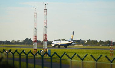 Dubli, İrlanda - 10.11.2021: Dublin havaalanında Ryanair uçağı. Ticari uçak jeti güzel gün batımı ışığında iniyor. Uçuş ulaşımı havayolu arka planı kavramı.