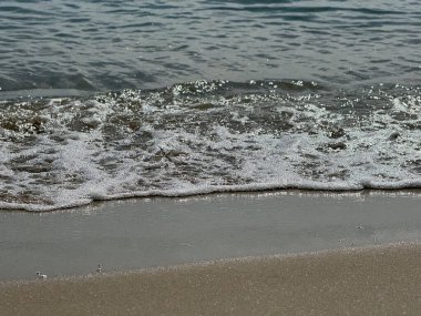 Okyanus dalgaları kıyıya vuruyor. Deniz köpüğü gibi görünür.
