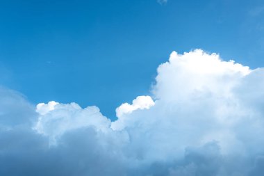 Yağmurlu bulutlar beyazı karanlığa dönüştürüyor ve mavi gökyüzünde genişliyor..