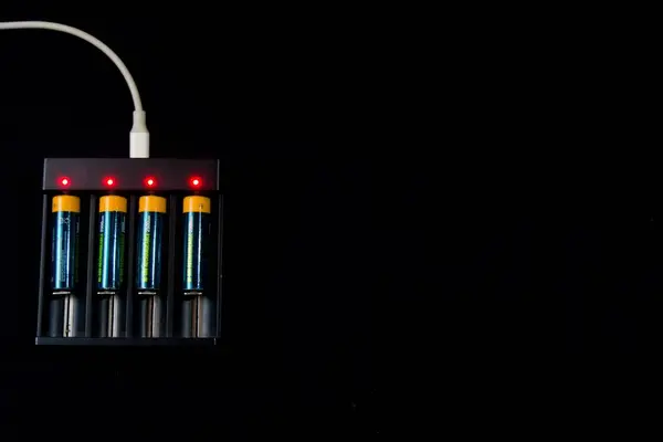 Şarj edilebilir batarya adaptörünün 4 şarj kompartımanı, siyah arkaplanda izole edilmiş.