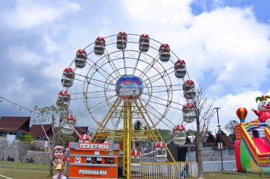 Güneşli bir günde büyük tekerlekli dönme dolap.
