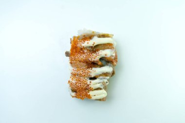 Suşi rulosunun yakın çekimi, üzerine sos serpilmiş ve tobiko serpiştirilmiş.