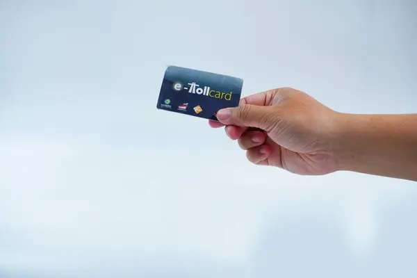 Bandung, Endonezya, 30 Aralık 2024: E-Toll Kart beyaz arka planda izole edilmiş eller tutun