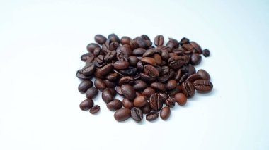 Beyaz arka planda izole edilmiş bir avuç kahve çekirdeği.