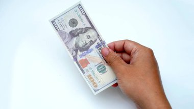 Elinde 100 dolarlık banknot var. Finans, tasarruf ve yatırım kavramı.