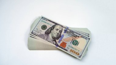 Beyaz arka planda 100 dolarlık banknotlar yığını. Zenginlik, tasarruf ve finans kavramı.