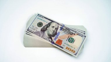 Beyaz arka planda 100 dolarlık banknotlar yığını. Zenginlik, yatırım ve finans kavramı.