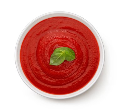 Beyaz arka planda izole edilmiş fesleğen yapraklı domates çorbası.