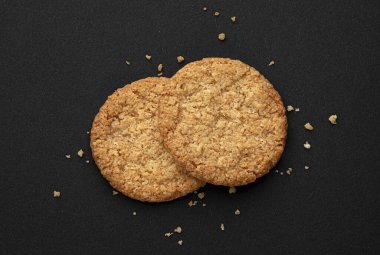 Siyah arkaplanda yulaf ezmesi kurabiyeleri. Kopya alanı, üst görünüm, tam derinlik