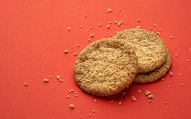Kırmızı zemin üzerinde iki yulaflı kurabiye, fotokopi alanı ile üst görünüm, tam derinlik