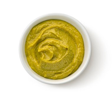 Beyaz arka planda izole edilmiş ev yapımı yeşil humus kasesi.