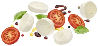 Düşen mozzarella peyniri ve fesleğen yapraklı domates dilimleri, balzamik sos, beyaz arka planda izole edilmiş kırmızı salata malzemeleri kırpma yolu ile izole edilmiş.