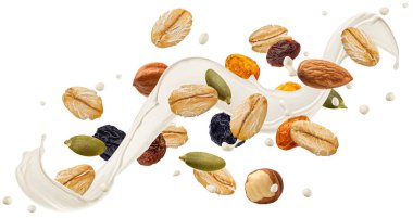 Düşen müsli malzemeleri, beyaz arka planda izole edilmiş süt sıçramalı yulaf lapası.