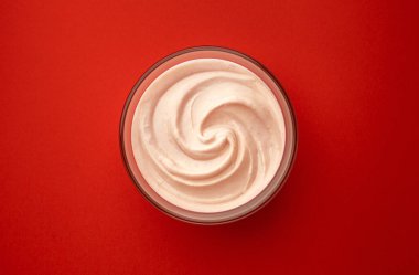 Kırmızı arkaplanda bir kase çilekli yoğurt, fotokopi alanı, üst görünüm