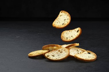 Düşen bruschetta krakerleri, siyah arka planda izole edilmiş yuvarlak ekmek kırıntıları, fotokopi alanı, tam derinlik