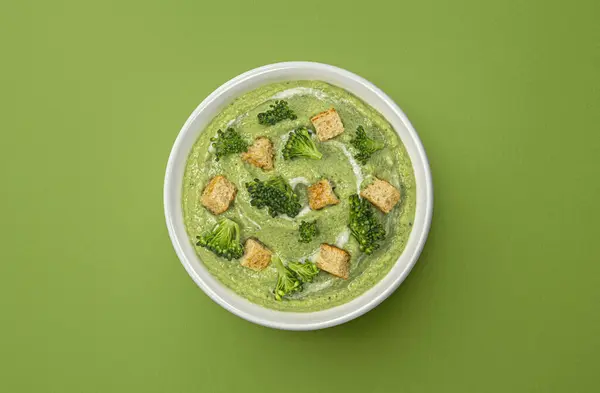 Sopa Crema Brócoli Con Croutons Sobre Fondo Verde Con Espacio Imagen de archivo