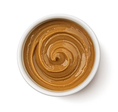 Beyaz arka planda izole edilmiş fıstık ezmesi girdabı, üst görünüm