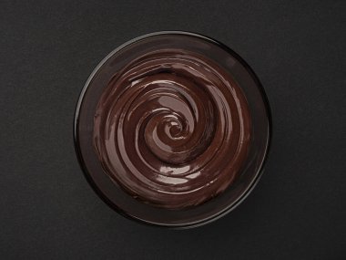 Eritilmiş çikolatalı krema, cam kasede, siyah arka planda, fotokopi alanı, üst görünümde.