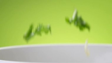 Marul yaprakları ve taze kesilmiş sebzeler yavaş çekimde kaseye düşüyorlar, ticari video konsepti.