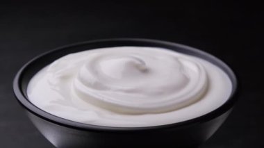 Bir kase taze yoğurt, fotokopi alanı olan siyah arka plan, yakın çekim.