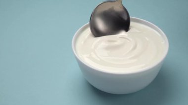 Yakın çekim kaşık ve doğal yoğurt dokusu, taze ve kremalı tatlı, ticari video konsepti