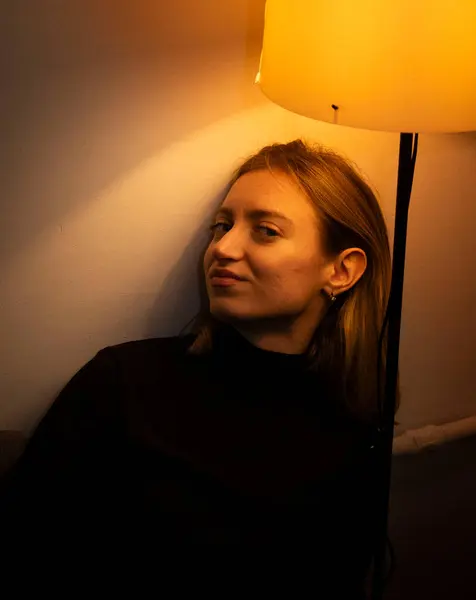 Odada poz veren genç bir kadının dikey çekimi.