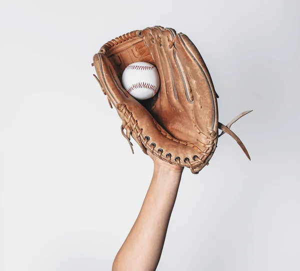 Baseball is caught in worn baseball glove.