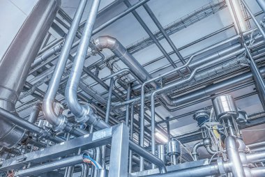 Fabrikadaki paslanmaz çelik borular. Gıda üretimi üzerine inşaat, soyut endüstri geçmişi.