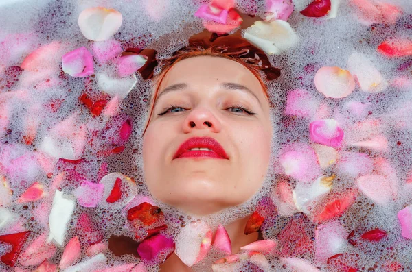 Egy Gyönyörű Arca Fürdőszobában Hab Rózsaszirmok Között — Stock Fotó