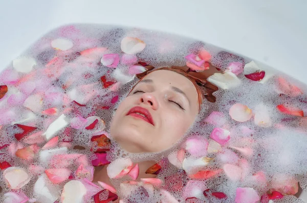 목욕중에 암컷의 얼굴을 부드러운 장미꽃 잎으로 덮는다 광고를 아름다움 스타일 — 스톡 사진