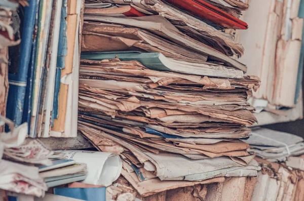 Documents, old papers in folders on shelves are stacked in a mess