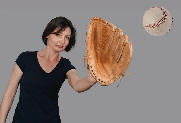 Slender woman catches baseball with a baseball glove