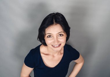 Neşeli, koyu renk saçlı kadın portresi. Üst Manzara. Mutluluk ve sevinç duyguları. Kar beyazı gülümseme.