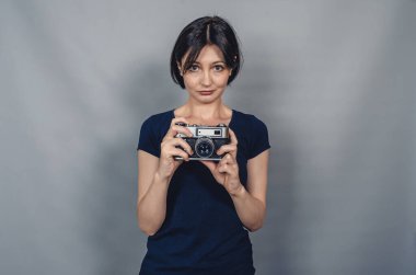 Kameralı kadın. Günlük giysiler. Gri arkaplan