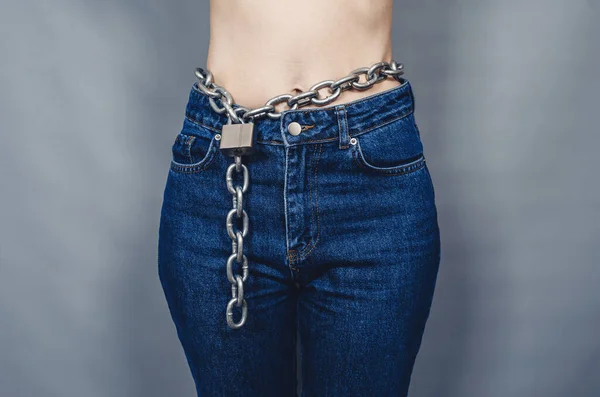 Chain on a woman\'s belt. Silhouette of  woman with  chain and  lock.
