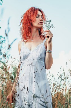 Red woman among dry grass in garden