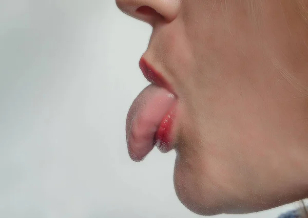 Profile of woman showing tongue. Side view
