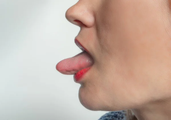 Profile of woman showing tongue. Side view